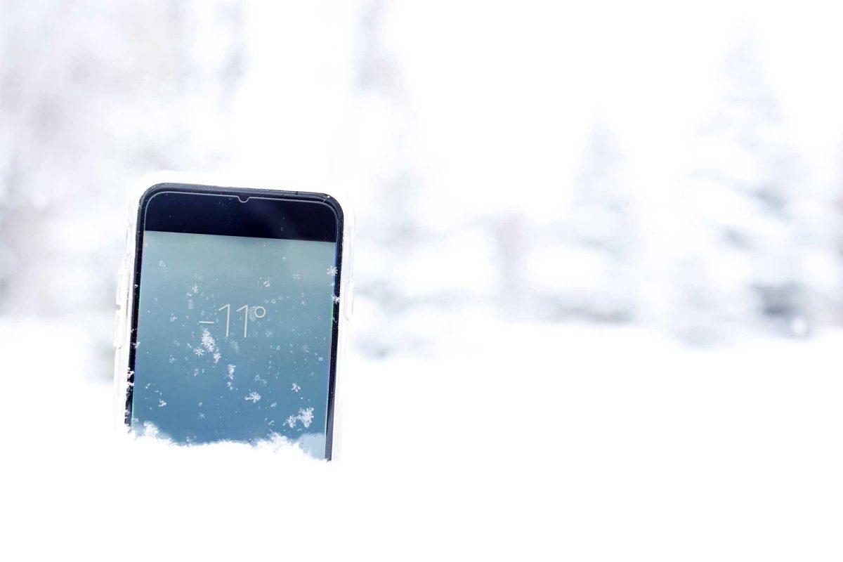 cell phone in snow showing why your phone battery dies so fast in the winter
